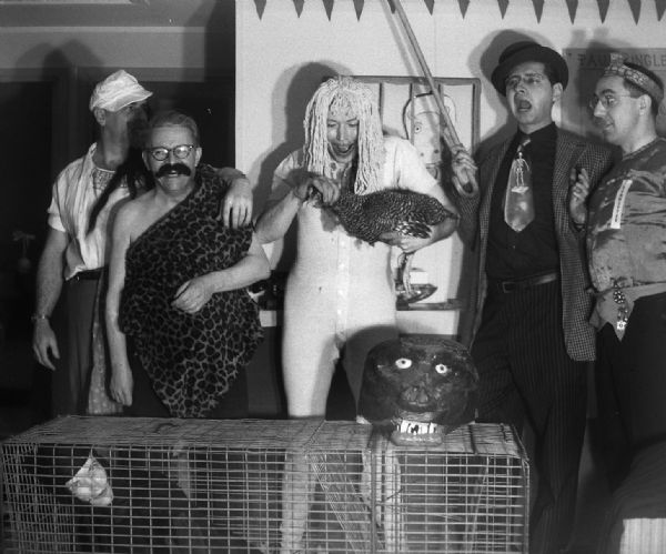 Group portrait from a humorous "Geek" party in Chester Vonier's county owned barracks. Joe O'Hearn was the editor of <i>Trains</i> magazine, Vonier was night editor of the Milwaukee Sentinel. Dorothy Madle was a reporter for the Sentinel and came dressed as a leopard.