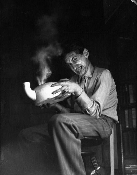Sinister photograph of Bloch conjuring "spirits" from a smoking chamber pot. The image was leter retouched with horror faces double printed into the smoke.
