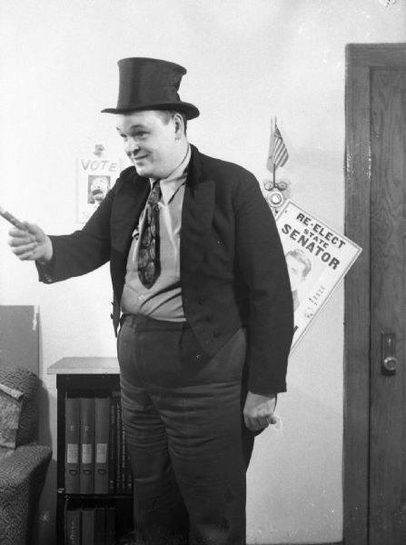 This character of a "ward worker" photograph was taken for <i>Smiles</i> magazine. On the wall behind the man a small American flag is propped on the apartment intercom.