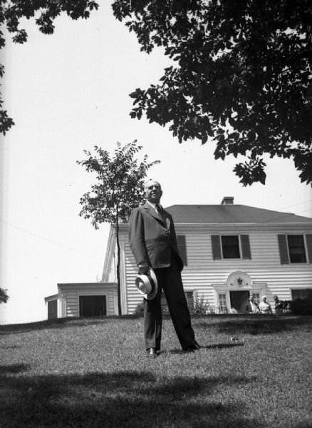 Image of Clausen for his campaign booklet. It was titled: "Clausen Looks Ahead" or "Clausen Looks to the Future." Gauer noted that it had to be retaken because the image of Clausen looked bad when used as a "cut-out." There is a house in the background, and three people near the front door.