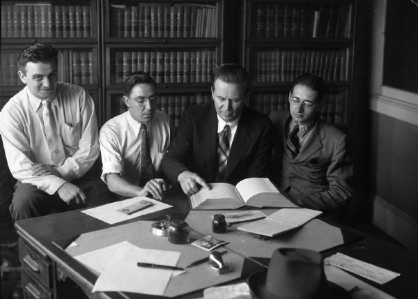 Photograph was taken as a record of Amlie's main team, at headquarters. From left to right: Unknown lawyer, Harold Gauer, Tom Amlie, and Robert Bloch.