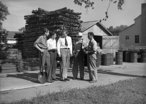 Robert Bloch, Harold Gauer, Tom Amilie, and two unknown men at Amlie's home. Taken to illustrate campaign brochure of Amlie talking to "farmer types."
