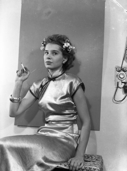 Costume party portrait of Angie Vail (nee Sianjn), taken in Harold Gauer's Brady Street apartment. On the wall a small American flag is propped on the apartment intercom.