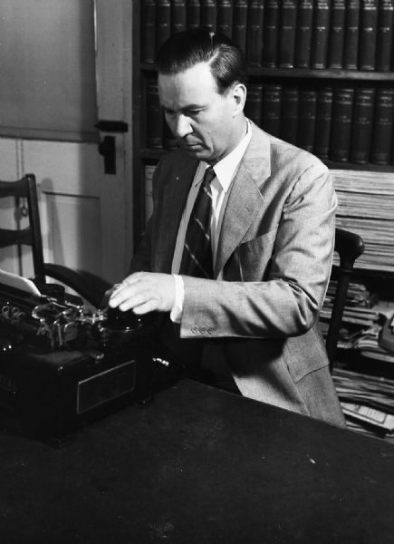 Photograph of Amlie working at a desk. The photograph was taken for his race with Smith in the Racine district.