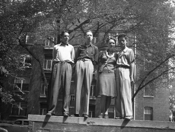 Harold Gauer and Robert Bloch with C.L. Moore and Henry Kuttner, who were visiting from California. They are standing outside on a wall in front of Bloch's parent's apartment.