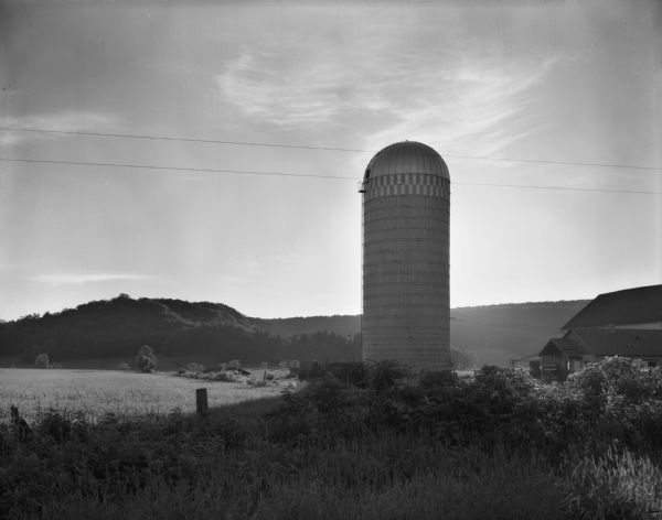 A rural landscape with a barn and silo.