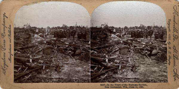 View of debris, perhaps from tornado damage in the business district of New Richmond. A group of onlookers investigate the damage. Caption on stereograph reads, "9667-In the Heart of the Business Section, New Richmond, Wis., June 12, 1899."