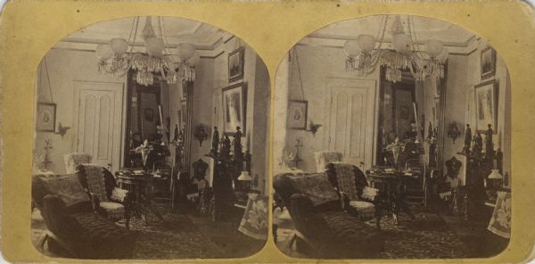 The interior of the Ole Bull Residence at 130 East Gilman Street, featuring good views of Victorian furniture, carpeting, lamps (including a crystal chandelier), pictures, small statues and a fireplace. Later, the house was known as the Thorp House. It became the executive mansion for the governor of Wisconsin in 1885 and later the Knapp Graduate Center.