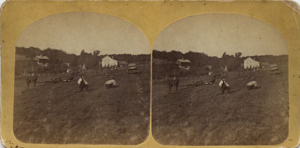 Two men rest in a field, with other individuals visible in the background. There appears to be a child on a horse on the left, and a group in a horse-drawn buggy or wagon. Also in the distance, a farmhouse and barn are visible.