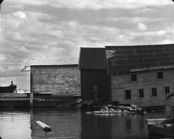 View from water of the sides of three wharf buildings in a bay of Lake Superior.