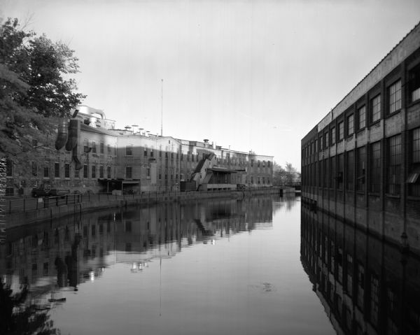 View of a canal running between the Neenah Paper Company and the J.W. Hewitt Machine Company.