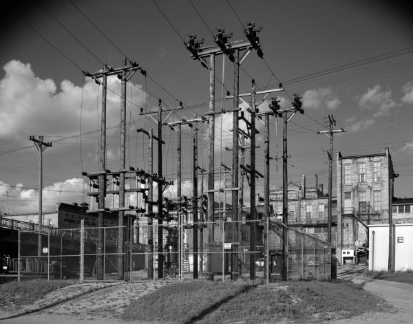 View of an electric utility station juxtaposed against commercial buildings.
