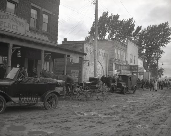 View of a downtown street, altered by 20th Century Fox motion picture studio for scenes in the movie "Young Man." For filming, local people dressed the part as extras and vehicles from the year 1916 were parked along the street.
