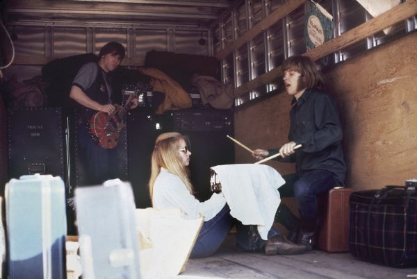 Guitarist Dick Wiegand and drummer Denny Craswell of Minneapolis rock band Crow, along with an unidentified woman, practice in the back of a moving truck before performing at Sound Storm.