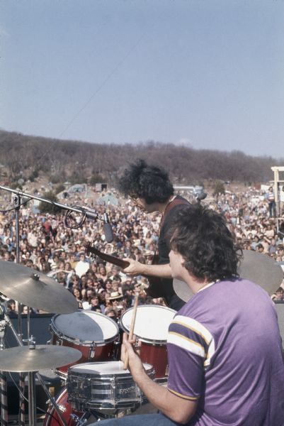View from stage looking out towards crowd of Jerry Garcia and Bill Kreutzmann playing guitar and drums (respectively) with the Grateful Dead at the Sound Storm music festival.