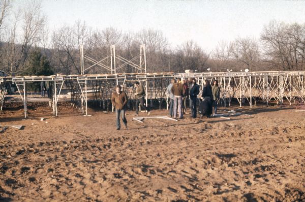 A small group of workers mill around the foot of the festival stage mid-construction.