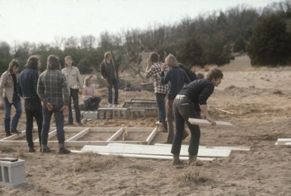 People on a construction crew work with plywood and cinder blocks to make stalls at the Sound Storm music festival.