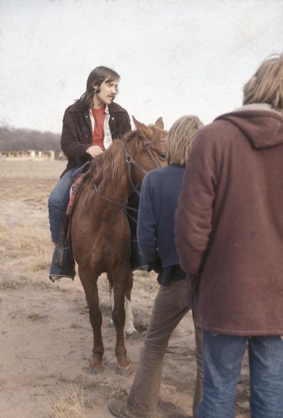 Peter Obranovich (better known at the time as "Pete Bobo"), promoter for the festival, talking to a small group of festival staff from horseback at the Sound Storm music festival.