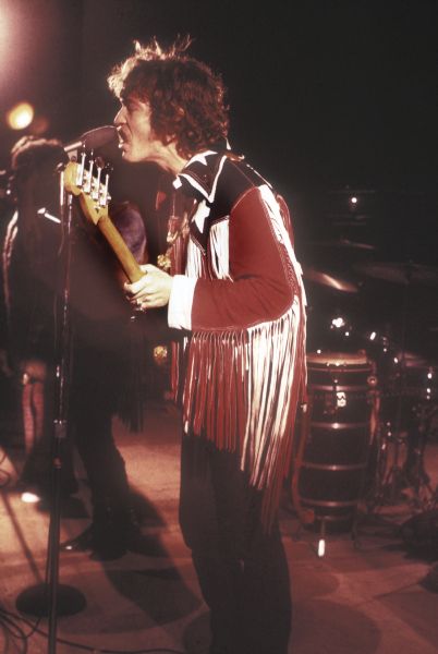 Mitch Aliotta, bassist for the psychedelic soul band Rotary Connection, on stage at the Sound Storm music festival. He is wearing a red, white and blue leather jacket with long fringe on the arms.