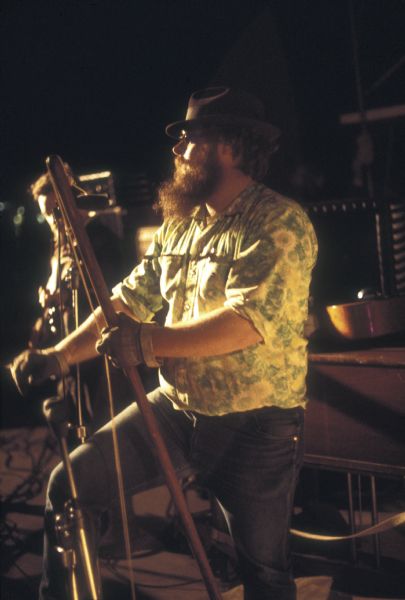 Bob Stelnicki, bass player for the Sorry Muthas, playing a washtub bass, or "gutbucket" style bass on stage at night at the Sound Storm music festival.

