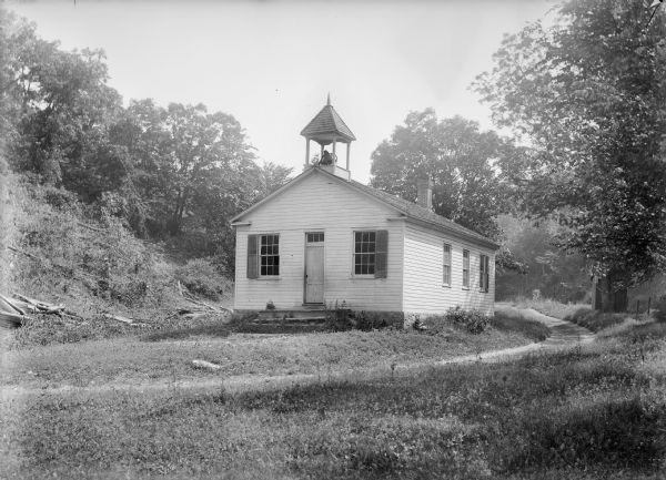 Lower Beetown clapboard schoolhouse with bell tower and path.