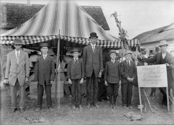 Six young men, winners of the Wisconsin No. 7 corn contest, pose in front of tent.
From left to right: Ray Peterson, Everett Palmer, Earl Ward, Herbert Eck, Harold Ackerman, Jeffie Duncan.
