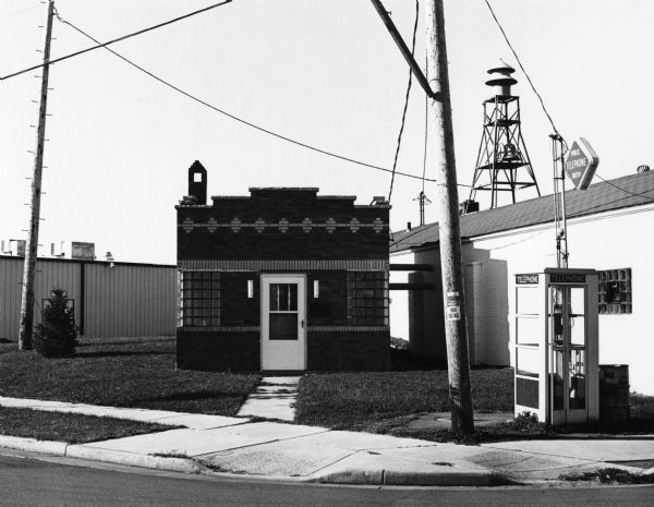 Municipal pumping station, corner of Main Street and Military Road. A telephone booth is on the right.