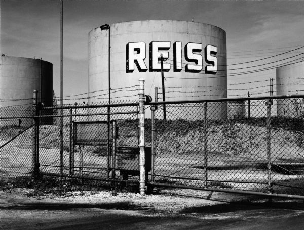 Reiss Oil Company yard, with large tank, at the end of East Water Street.