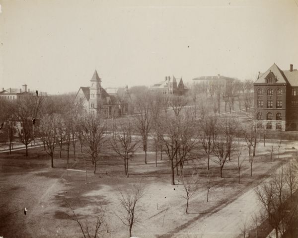Elevated view over Langdon Street of the University of Wisconsin-Madison campus. South Hall, Music Hall, and Science Hall are visible. Bascom Hill and a central area with trees (present-day Library Mall) are also visible.