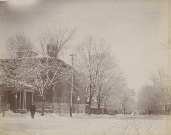 A view down snow-covered East Johnson Street from the corner of East Johnson Street and Wisconsin Avenue. Trees line the street and the Masonic Temple at 301 Wisconsin Avenue, is on the left.