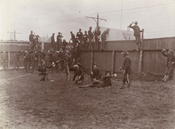 A group of soldiers from Company A, 3rd Regiment, take a break to drink inside the walls of Camp Harvey.