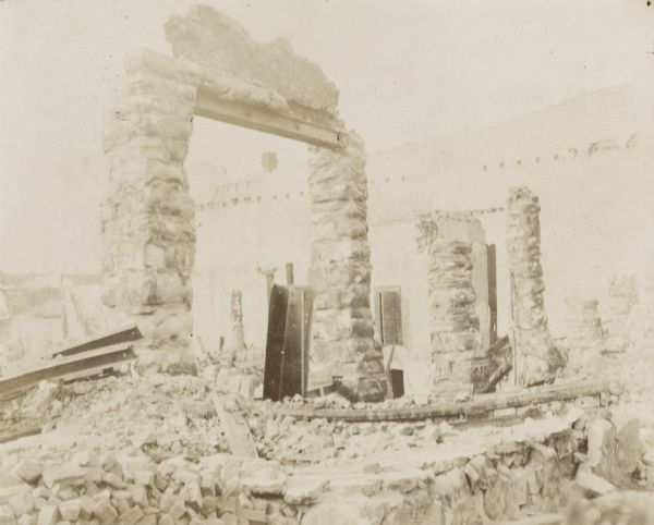 View of the ruins from a fire in the 3rd Ward. Stone rubble covers the ground and parts of two stone-frame structures are still standing.