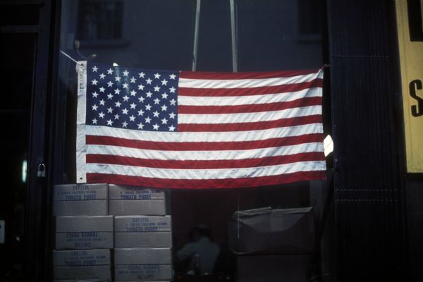 An American flag hangs near the construction of the World Trade Center towers.