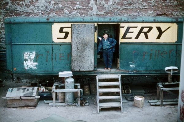 A construction worker leans in the doorway of a break trailer at the construction site of the World Trade Center.