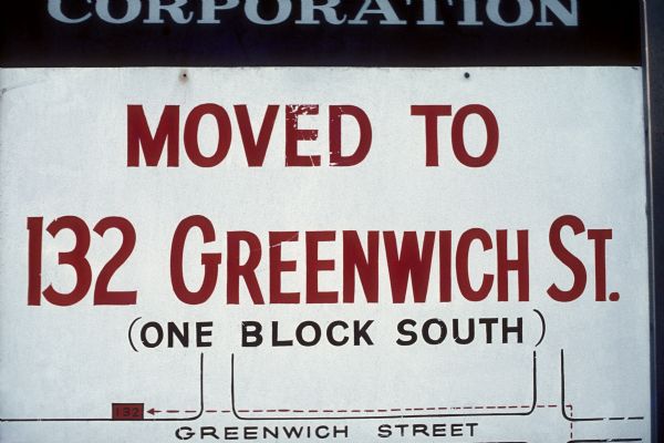 A sign reads that a business has "Moved to 132 Greenwich St. (one block south)." Along with the written description, there is a small map to show where the business has moved.