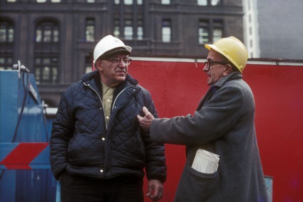 Two men talking at the base of the construction site of The World Trade Center.