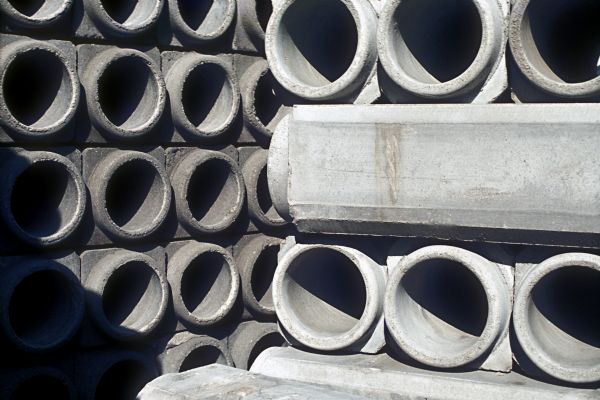 Large concrete pipes stacked outdoors.