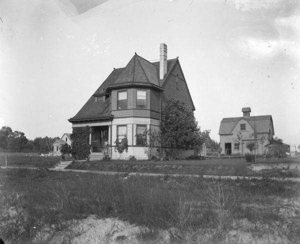 Exterior shot of Dankoler's house near Humbolt Park. A house and a barn-like structure are in the background.