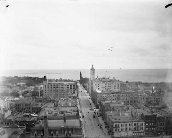 Elevated view from the top of the Pabst Building down East Wisconsin Avenue all the way to Milwaukee Bay and out to the horizon of Lake Michigan. One of the buildings is the "Goldsmith Building."