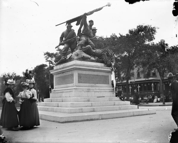 Women congregate near "The Victorious Charge," a monument to Soldiers who fought in the Civil War located in Milwaukee's Court of Honor on the median between the lanes of West Wisconsin Avenue. There is a wreath on the statue.