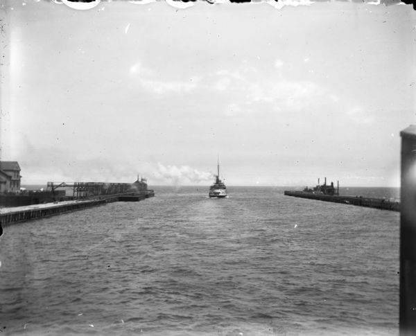 A boat leaving Milwaukee Harbor between two breakwaters, steaming into Milwaukee Bay and onward out into Lake Michigan.