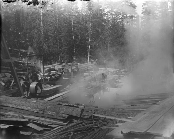 Men working at a sawmill outdoors in the Leighton-Wyoming mining camp.