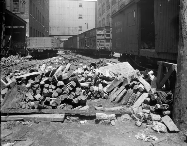 Piles of rubble along railroad tracks next to the McCormick Reaper Works. Railroad box cars are parked on the tracks. The photograph may have been taken to document damage from some type of mishap.