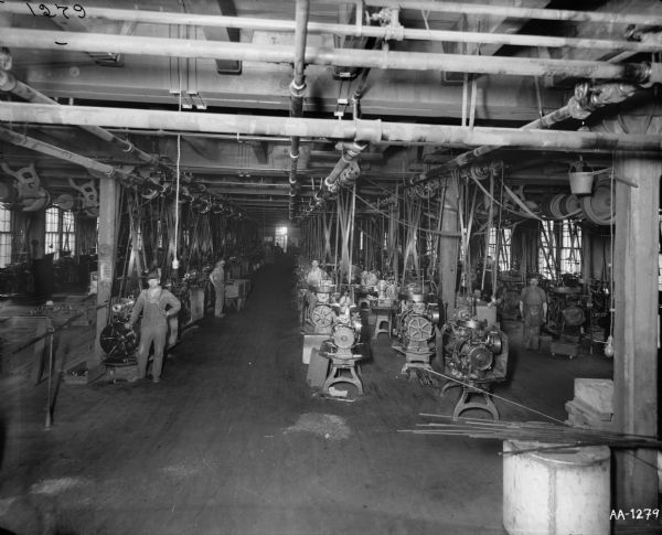 Factory workers standing at machines in the metal finishing room at the McCormick Works.