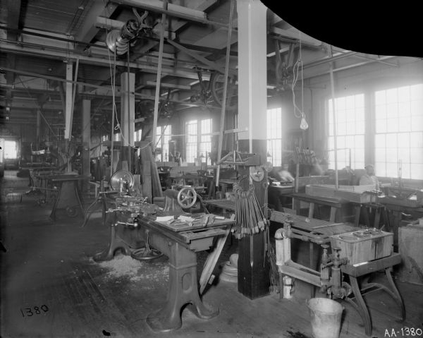 Machinery on a factory floor, most likely at McCormick Works. Workers are in the background.