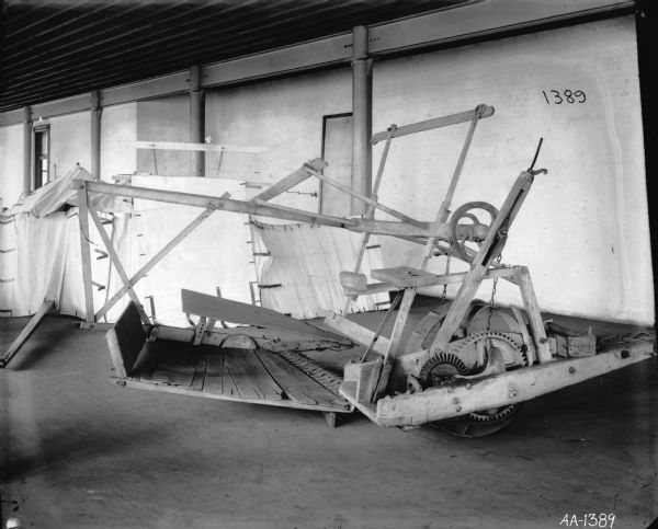 Early McCormick reaper at McCormick Works. There is a white sheet hanging in the background for a backdrop.