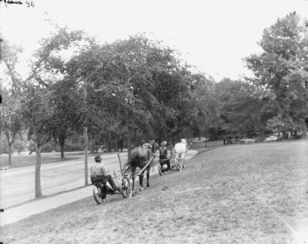 Two grounds keepers mowing lawn in Fairmount Park.