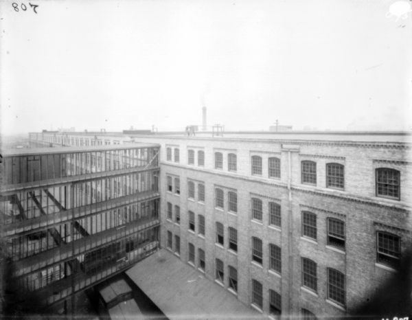 Elevated view of a building at McCormick Works under construction. There are railroad cars under a section of the building under construction.