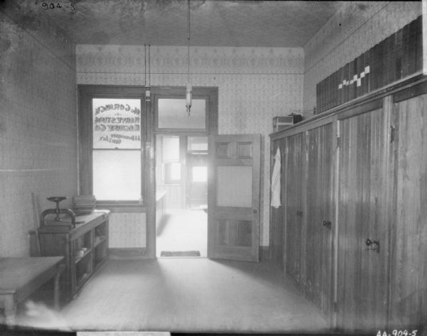 Interior view of office, looking towards open office door. Painted on the door: "McCormick Harvesting Machine Co., A.I. Dourgherty, Gen. Ag't."
