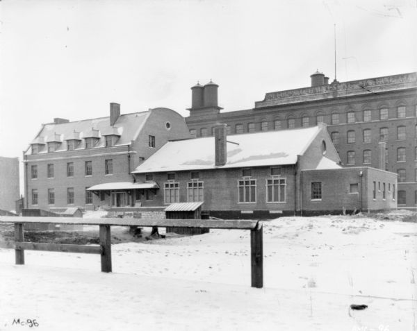 Exterior view in winter of the McCormick Works Club House. The factory buildings are in the background.